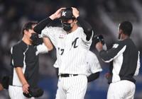 　試合後、風で飛びそうな帽子を両手で押さえて引き揚げる佐々木朗（撮影・開出牧）