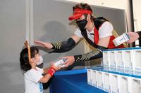 ファンにボブルヘッドを手渡す新庄ビッグボス（北海道日本ハムファイターズ提供）