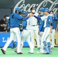 　１０回、サヨナラ勝ちし、生還した中島（右）とグータッチを交わす新庄ビッグボス（撮影・中島達哉）