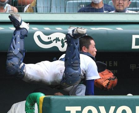 　５回、一関学院・小松の邪飛を追って、一関学院ベンチに飛び込む明豊・鈴木（撮影・北村雅宏）