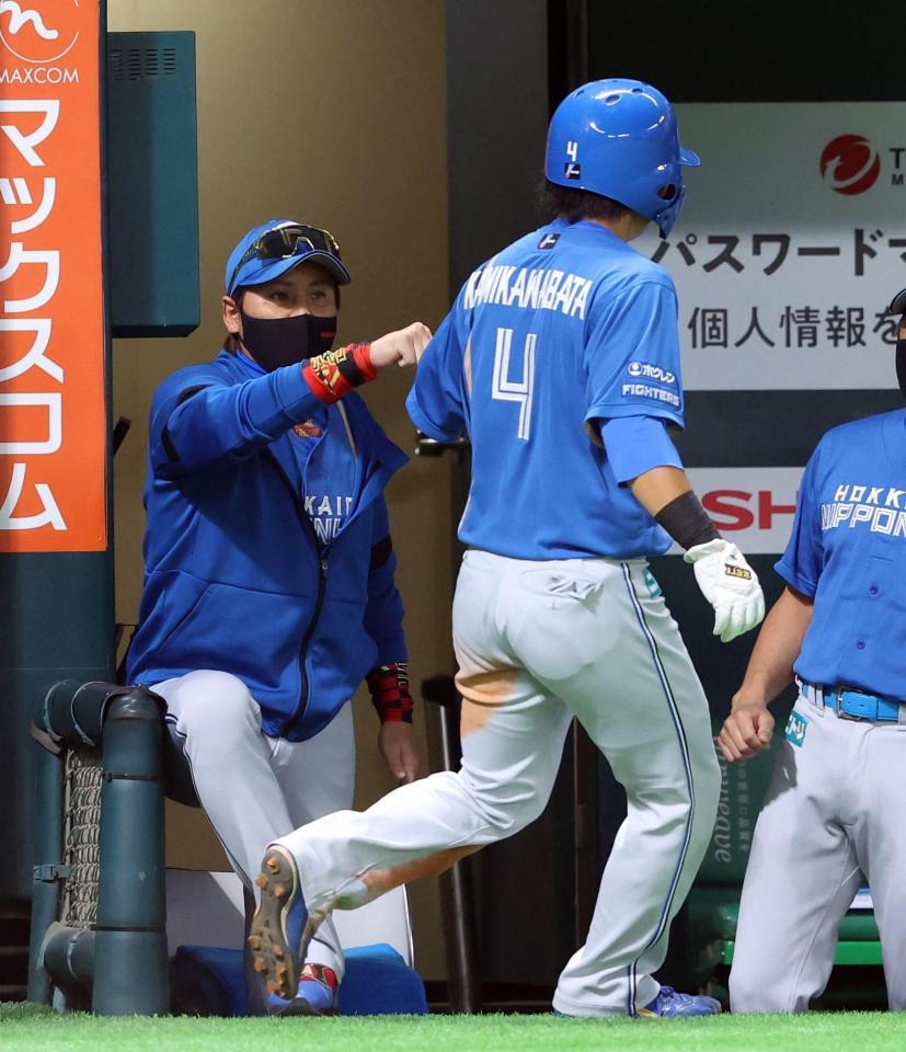 　２回、佐藤のスクイズで生還した上川畑（右）を出迎える新庄監督