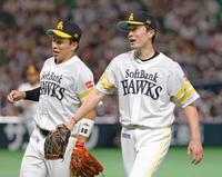 　４回を終え、好守の二塁手野村勇（左）とタッチを交わすソフトバンク・和田＝ペイペイドーム