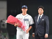 　高橋由伸氏（右）から花束を贈られた内海（撮影・佐々木彰尚）