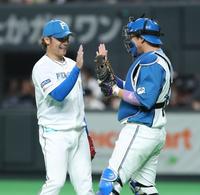 　９回に登板し、プロ初セーブをあげ、宇佐見（右）と笑顔でタッチを交わす伊藤（撮影・中島達哉）