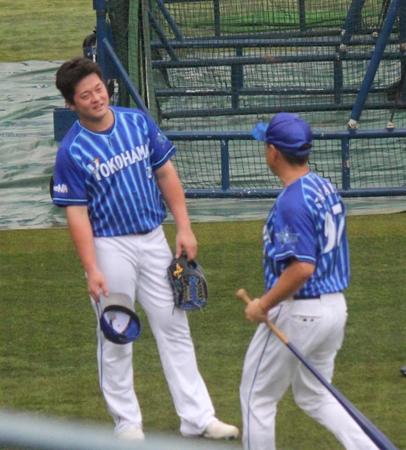 　田中内野守備走塁コーチ（右）からノックを受けた後、アドバイスを聞く牧