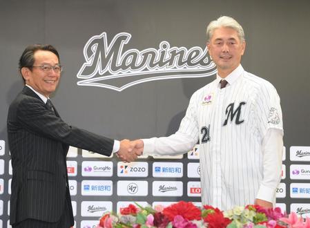 　河合オーナー代行兼社長（左）と握手をする吉井新監督（撮影・堀内翔）