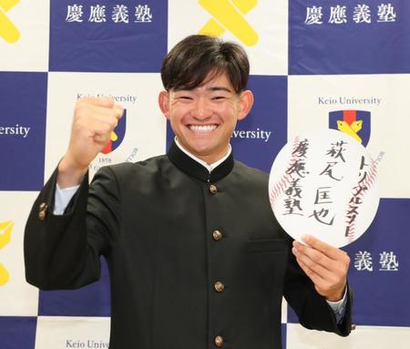 　巨人から指名を受け目標を書いた色紙を手に笑顔の慶大・萩尾匡也（代表撮影）