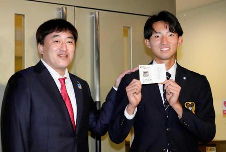 ドラフト会議の会場から駆けつけた楽天・石井監督（左）からもらった交渉権確定の紙を手にする立大の荘司