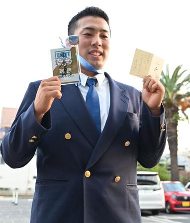 　原監督のメッセージの入った交渉権確定札を持って笑顔を見せる巨人ドラフト１位の高松商・浅野