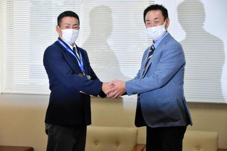 　水野スカウト部長と固く握手を交わす巨人ドラフト１位の高松商・浅野