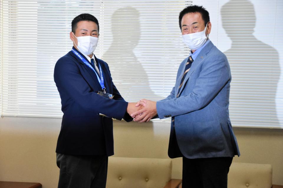　水野スカウト部長と固く握手を交わす巨人ドラフト１位の高松商・浅野