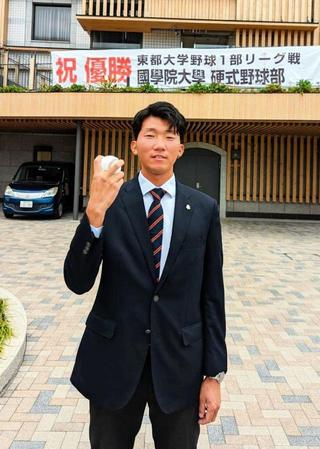 　決め球・フォークの握りを披露する国学院大の田中