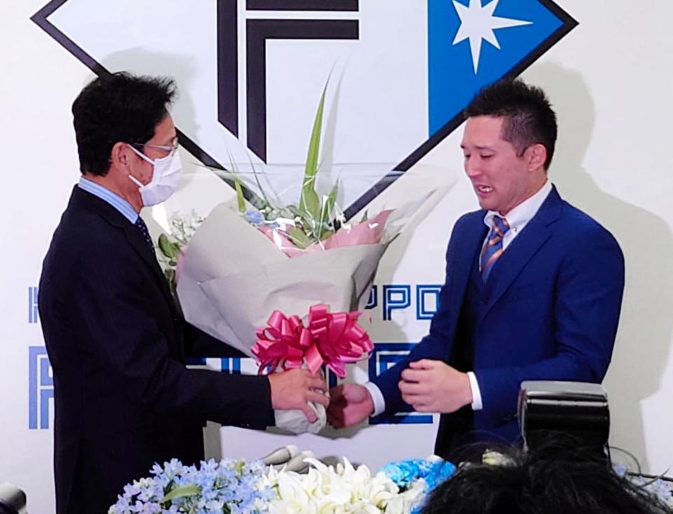 　杉谷（右）が引退会見。侍ジャパン監督で前日本ハム監督の栗山監督からサプライズで花束を手渡され涙