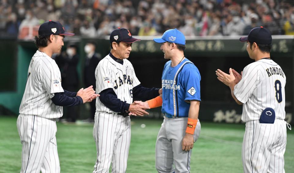 　伊藤（左）、栗山監督（同２人目）、近藤（右）からねぎらわれる杉谷（撮影・西岡正）