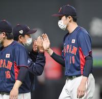 　オーストラリアに勝利し、栗山監督（左）とタッチを交わす佐々木朗（撮影・西岡正）