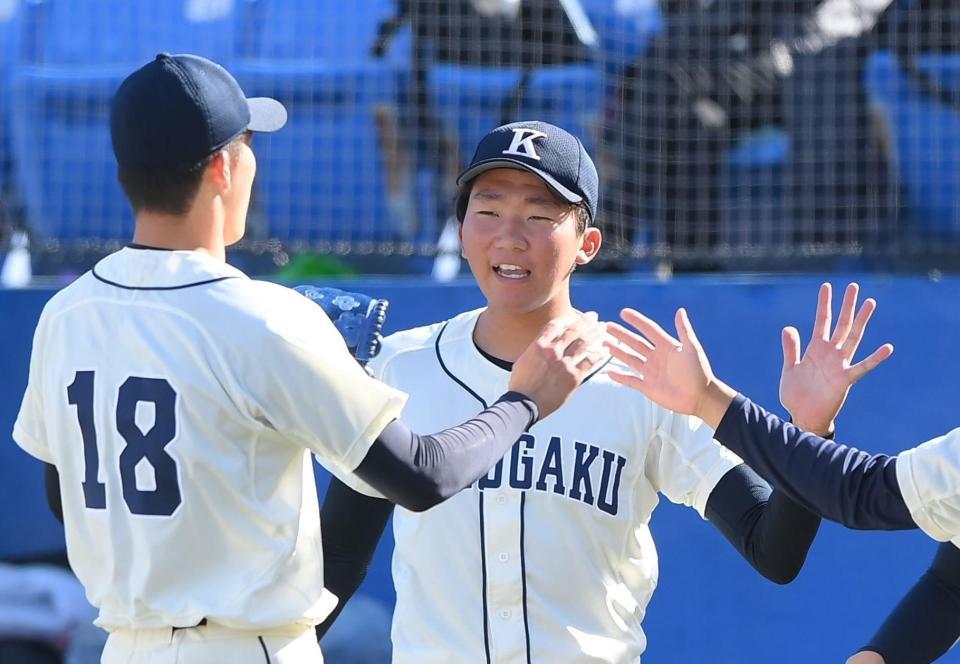 　６回途中から登板して好リリーフを見せた坂口翔颯（右）を迎える国学院大・田中千晴（撮影・堀内翔）