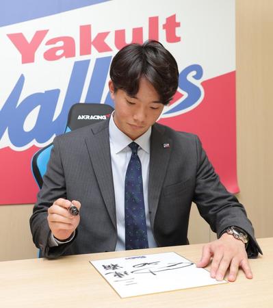 　契約更改後の会見で、来シーズンの目標を色紙に書き入れる木沢（代表撮影）