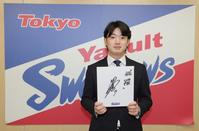 　契約更改後の会見で、来シーズンの目標を書き入れた色紙を持つ長岡（代表撮影）