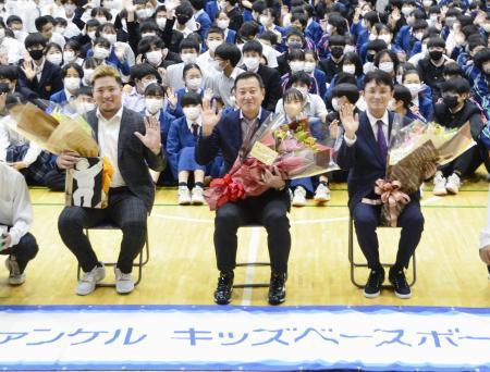 　母校の那覇市立城北中で生徒たちと記念撮影する西武・山川（左）。中央は巨人・原監督＝１６日