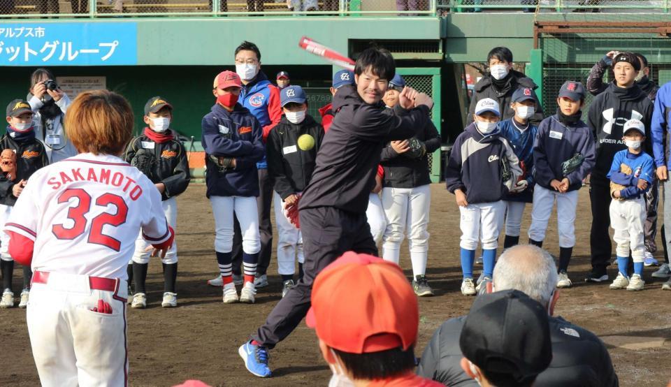 　子どもたちの前でロングティーを披露する島内（中央）