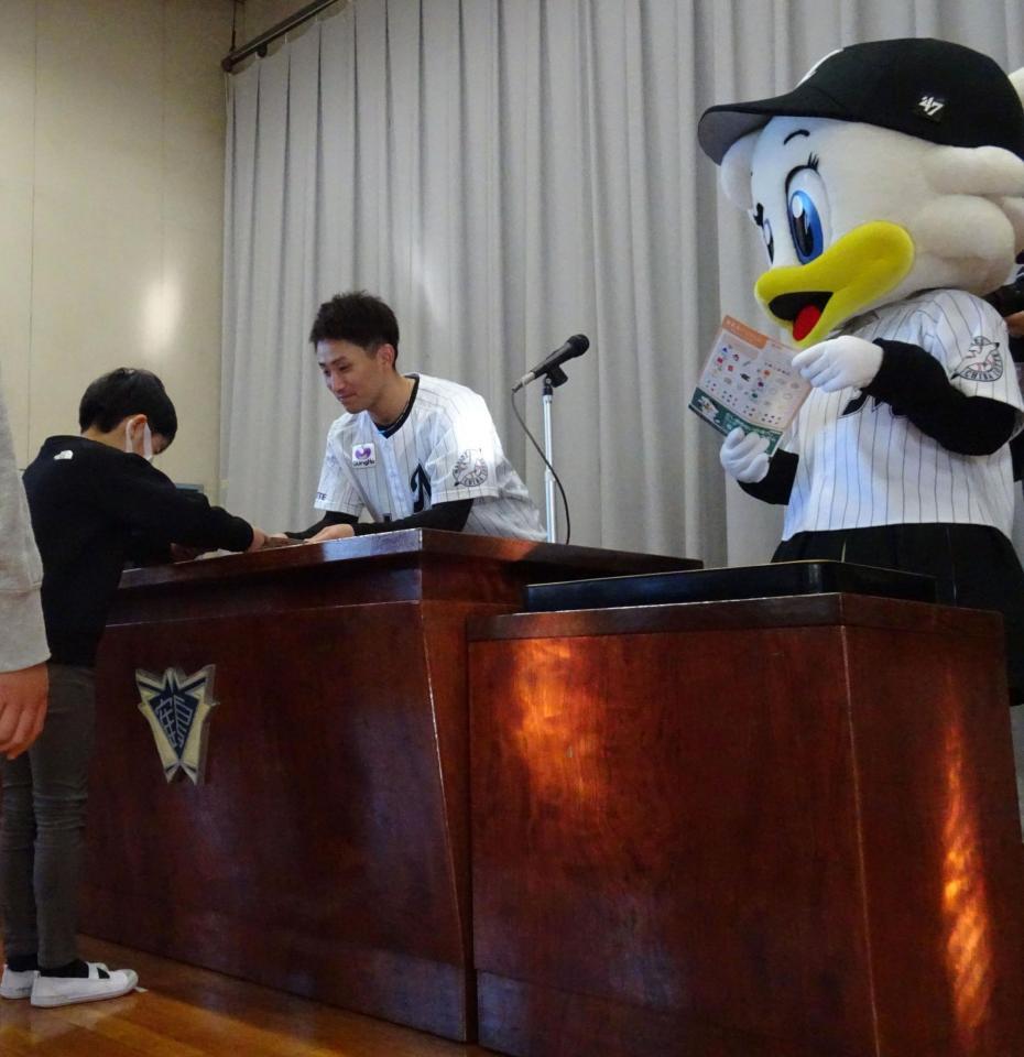 　千葉・鶴沢小のマリーンズドリル贈呈式で算数ドリルを配布する小島