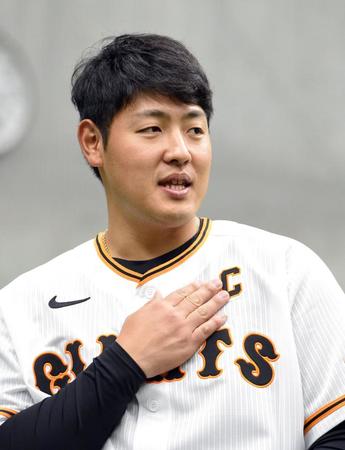 　ユニホームのキャプテンマークを触る岡本和（撮影・佐藤厚）