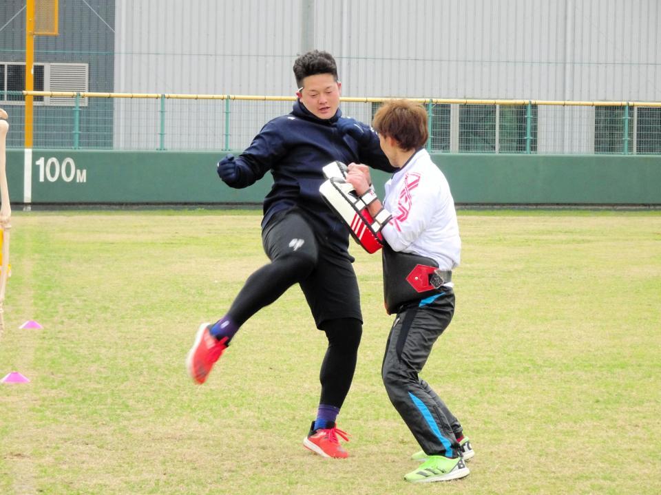 　サンドバッグを蹴り上げる牧