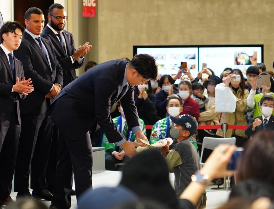 　たくさんのファンが見守る中、サインバットを子どもに手渡す村上（撮影・高石航平）