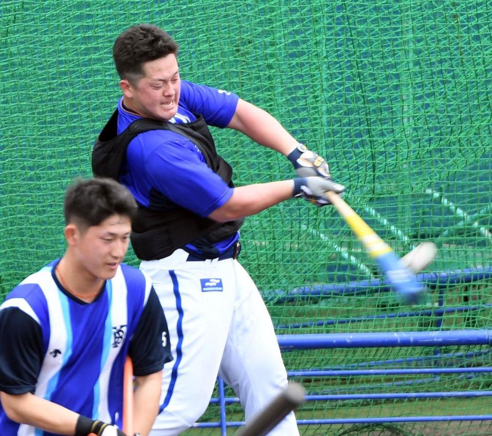 重り付きのベストを着てロングティーを打つ牧（撮影・佐藤厚）