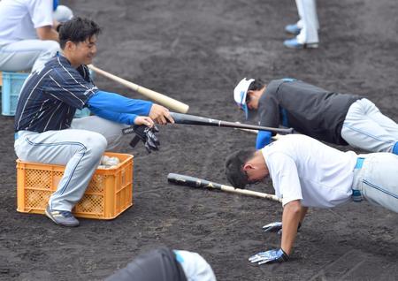 　ロングティー前に腕立て伏せをする阪口（右手前）にバットで追い込む清宮（左）＝撮影・伊藤笙子