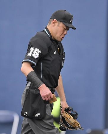 　右腕にテーピングを巻きつけ、続行する木内九二生審判（撮影・伊藤笙子）