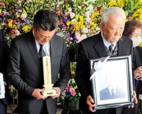 　入来智さんの告別式に参列する弟の祐作氏（左）右は父の嘉門さん