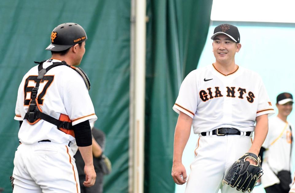 　ブルペンでの投球を終え、山瀬（左）と話す菅野（撮影・佐藤厚）