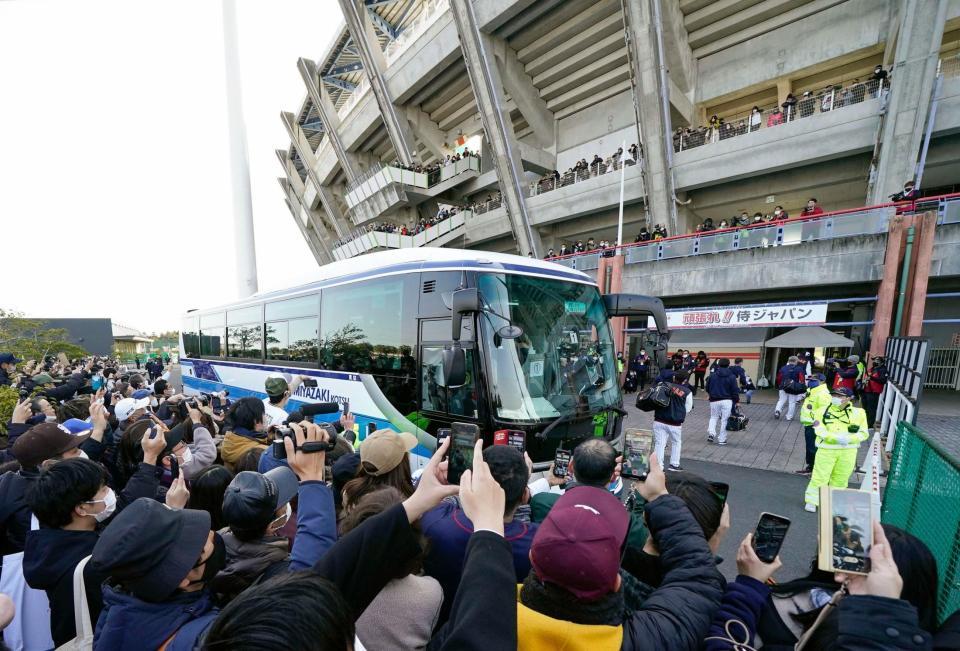 　選手を乗せたバスの到着にカメラを向ける大勢のファン