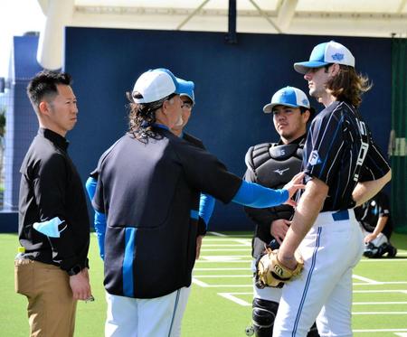 　ガント（右）はブルペンでの投球練習を終えてヒルマン氏（左から２人目）のアドバイスを受ける