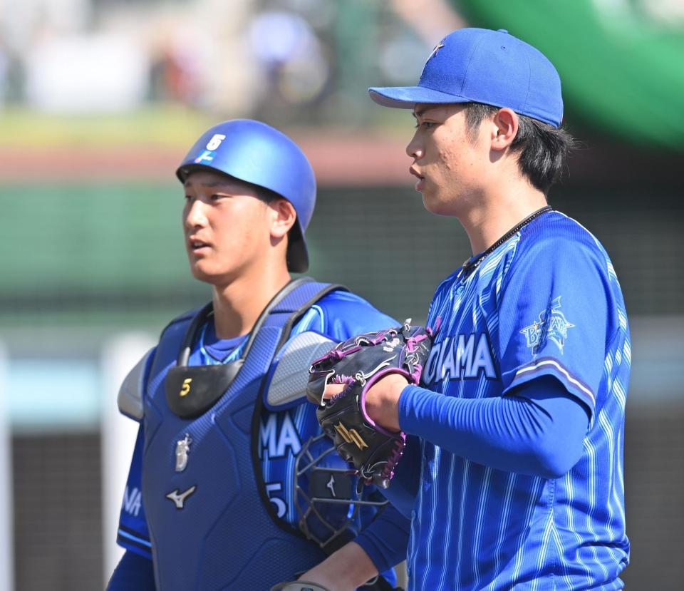 　８回を無失点に抑え、松尾（左）と話しながらベンチへ戻る小園（撮影・西岡正）