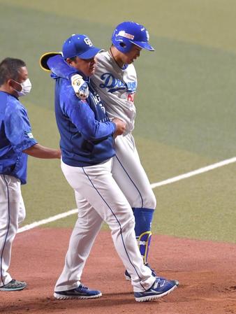 　ダルビッシュの投球を右膝に受け、抱えられるようにベンチへ下がる岡林（中央）＝撮影・伊藤笙子
