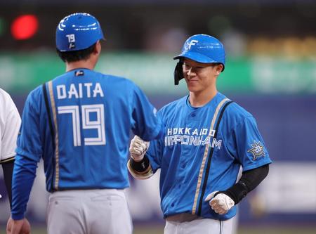 　６回、矢沢は右前にタイムリーを放ち、笑顔で代田コーチとタッチをかわす（撮影・坂部計介）