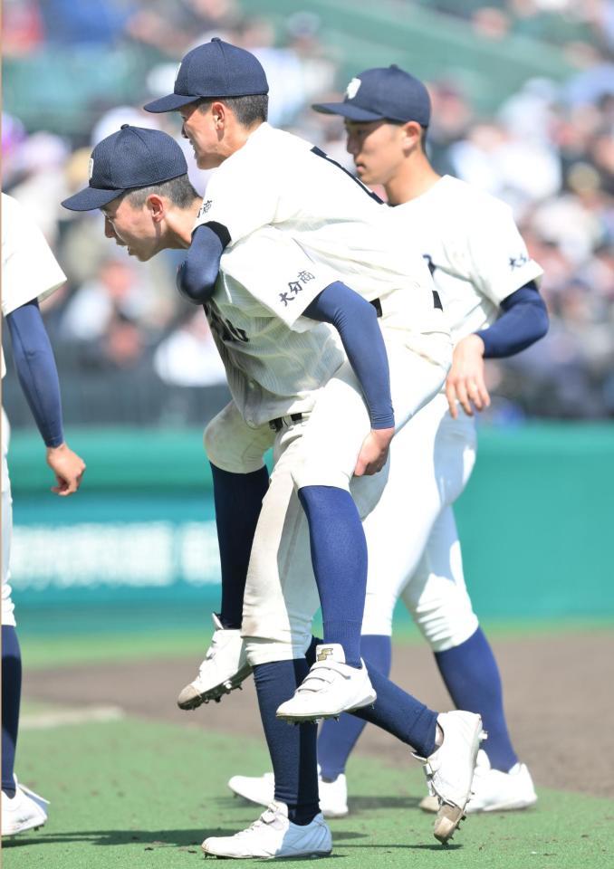 　７回終了後、おんぶされてベンチに戻る大分商・上田迅人（中央）＝撮影・伊藤笙子