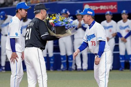 　ＷＢＣ優勝を記念したセレモニーで、立浪監督（右）から花束を受け取る吉井監督。左は高橋宏