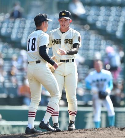　３回途中で降板し２番手の市川春之介（左）にボールを渡す作新学院の先発・川又楓（撮影・開出牧）