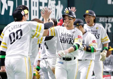 ６回、先制３ランを放ちナインに迎えられるソフトバンク・栗原（手前）＝ペイペイドーム