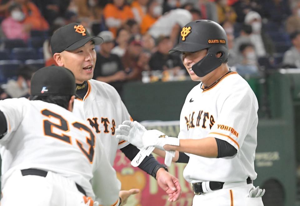 　７回、長野（右）は左前に勝ち越し適時安打を放ち、阿部ヘッドコーチに迎えられる（撮影・佐藤厚）