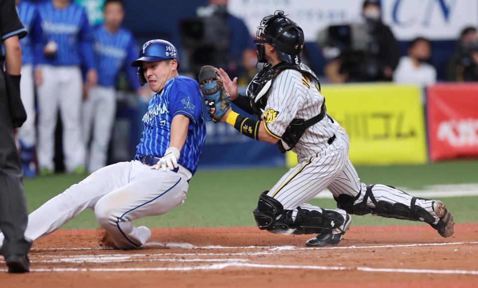 　７回、一走・佐野は宮崎の二塁打で本塁を狙うもアウトになる（捕手は梅野）＝撮影・山口登