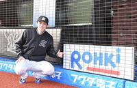 　今季初勝利を挙げバックネットに設置された看板「ＲＯＨＫｉ」を指さし笑みを浮かべる佐々木朗（撮影・開出牧）