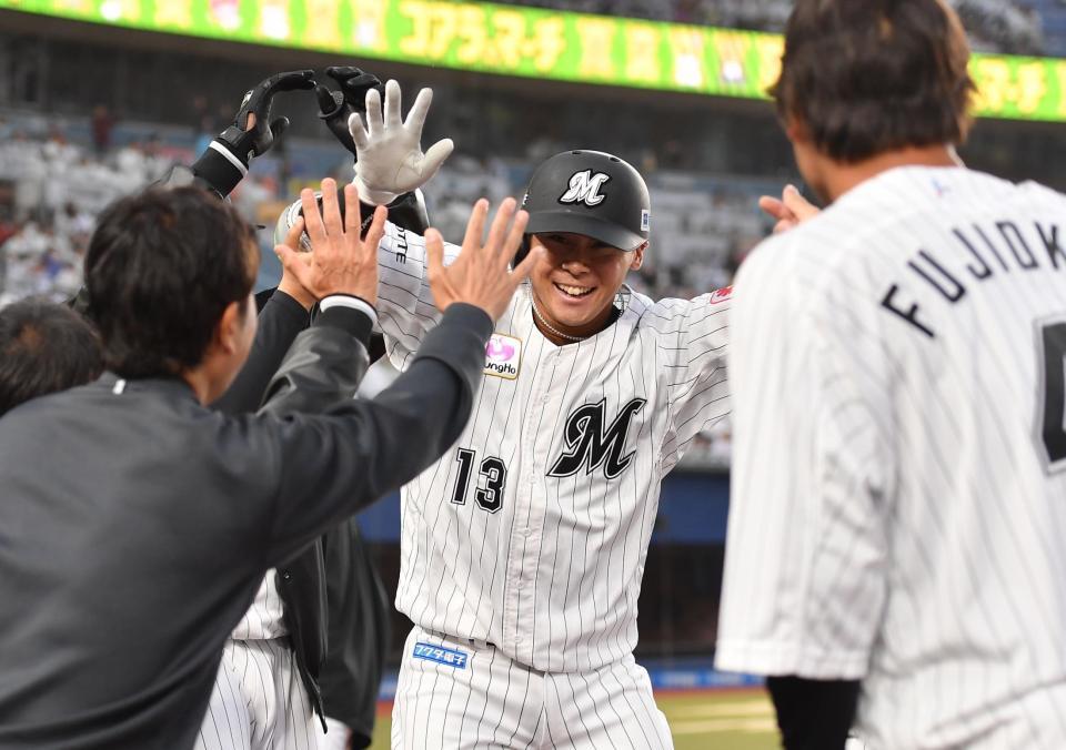 　８回、逆転の右越え２ランを放ちナインとタッチを交わす平沢（撮影・開出牧）