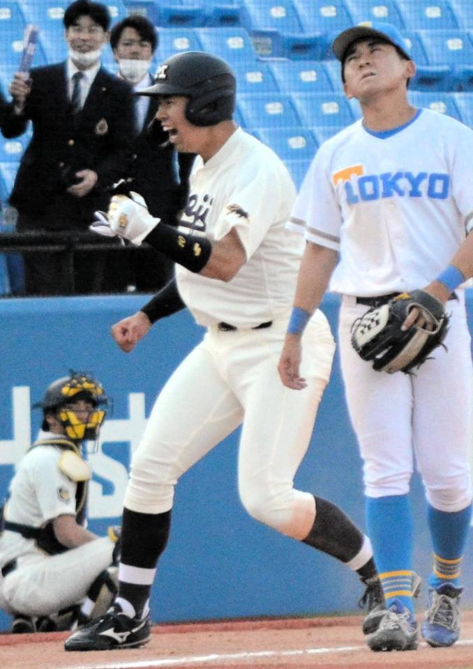 暴投で一塁から三塁に進塁し、ガッツポーズをする明大・上田