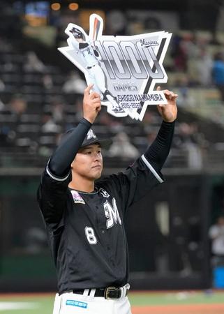 　通算千試合出場を達成し、ボードを掲げる中村奨