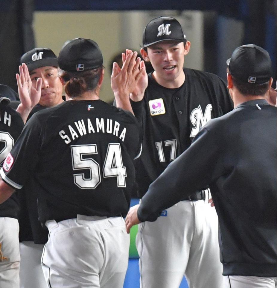 　２勝目を挙げ、沢村（左）とタッチを交わす佐々木朗（撮影・西岡正）