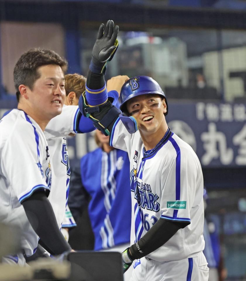 　７回裏、ランニングホームランを放ちファンの声援に応える関根。左は牧